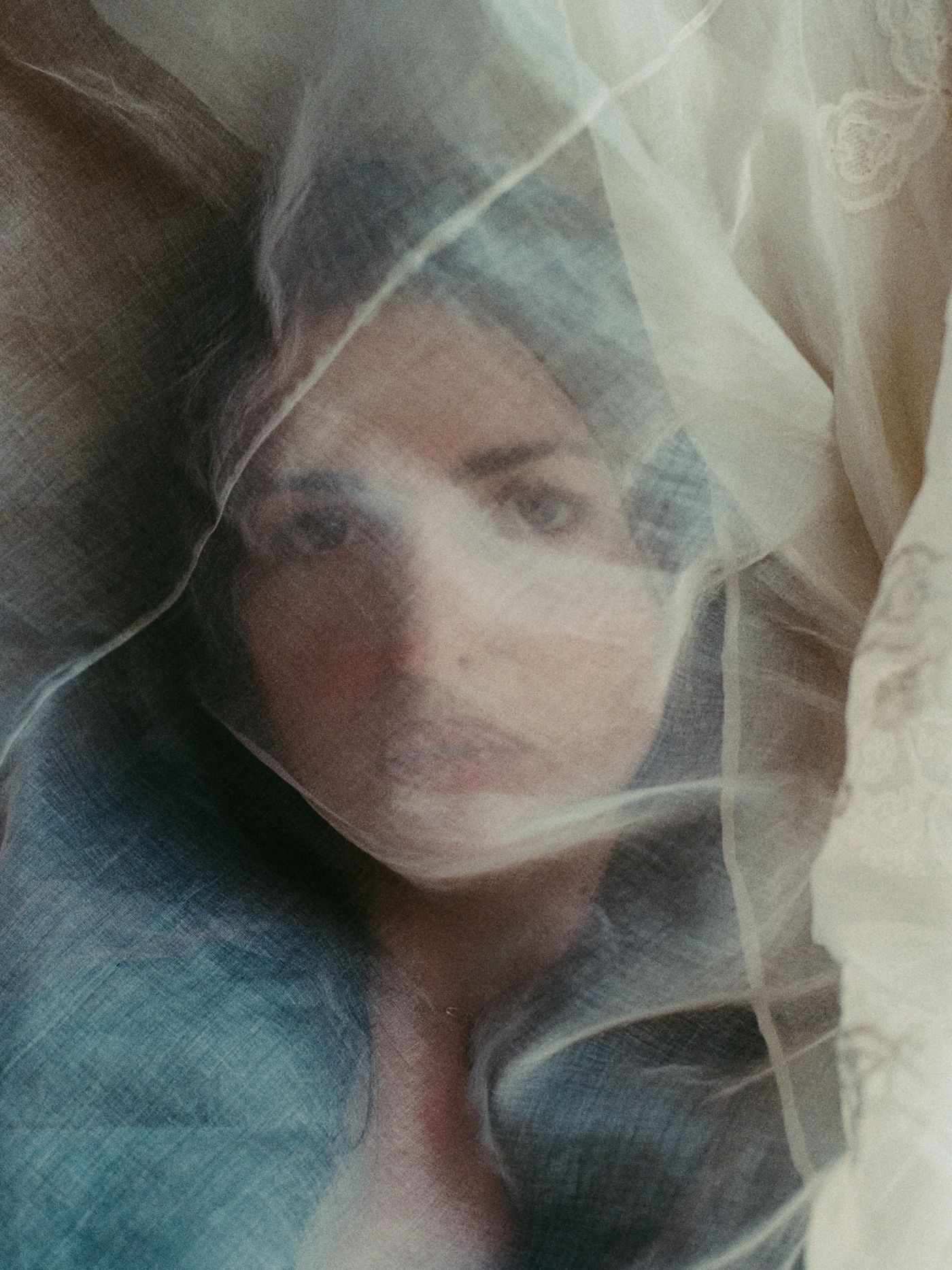 Marieke McKenna's face seen through a sheer embroidered veil